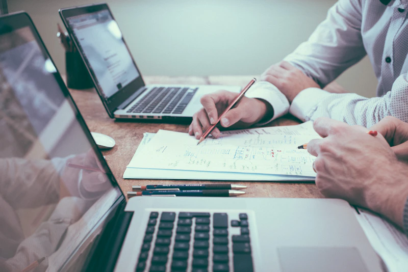 A person meticulously reviewing a stack of mortgage statements and financial documents